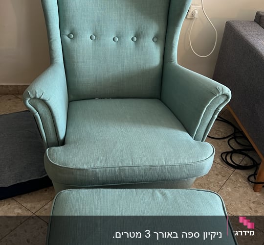 כורסה ירוקה עם הדום על רצפת אריחים